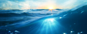 Solsken som skär igenom vattenytan på havet